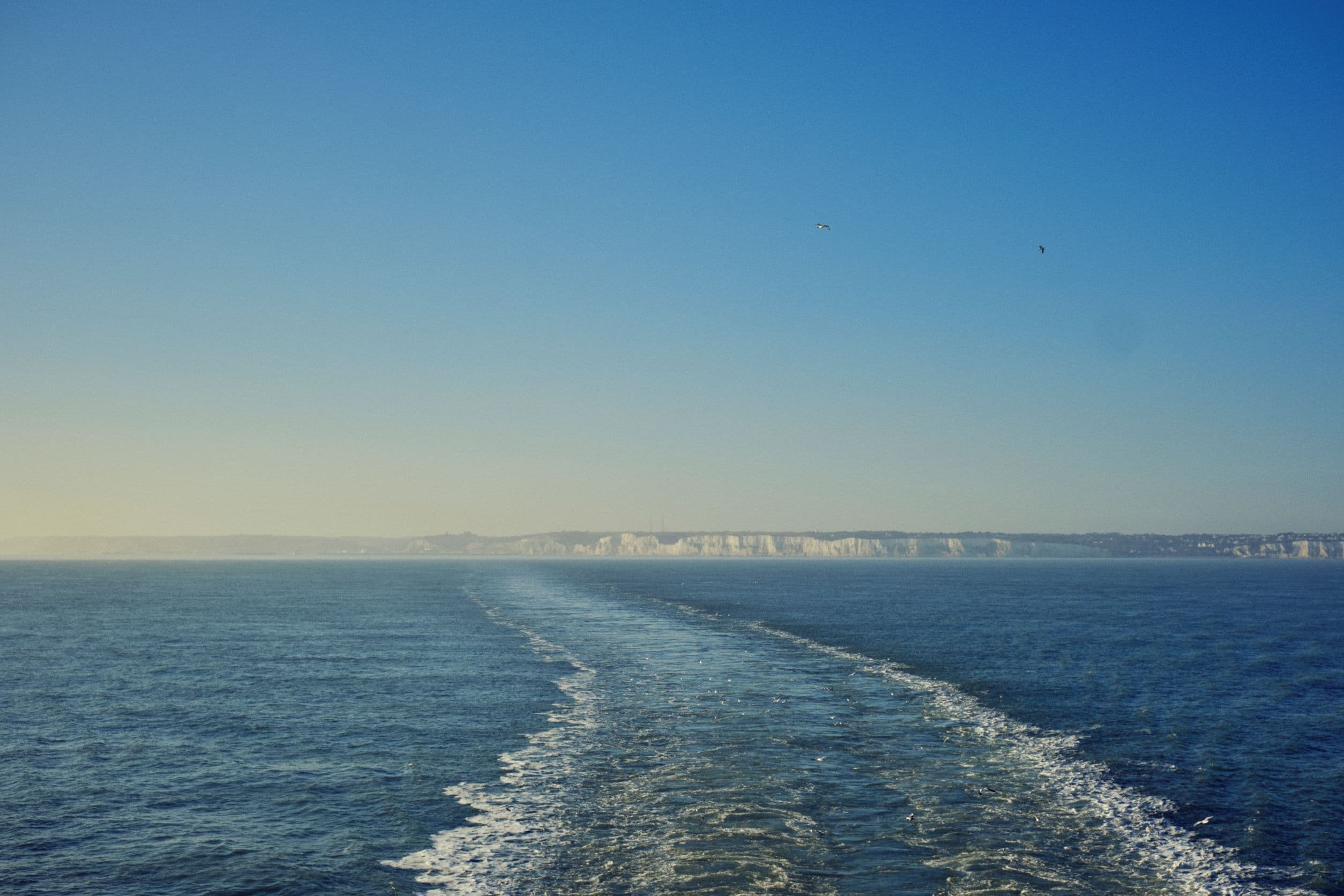 View of Dover's coastline taken from a ship sailing away.